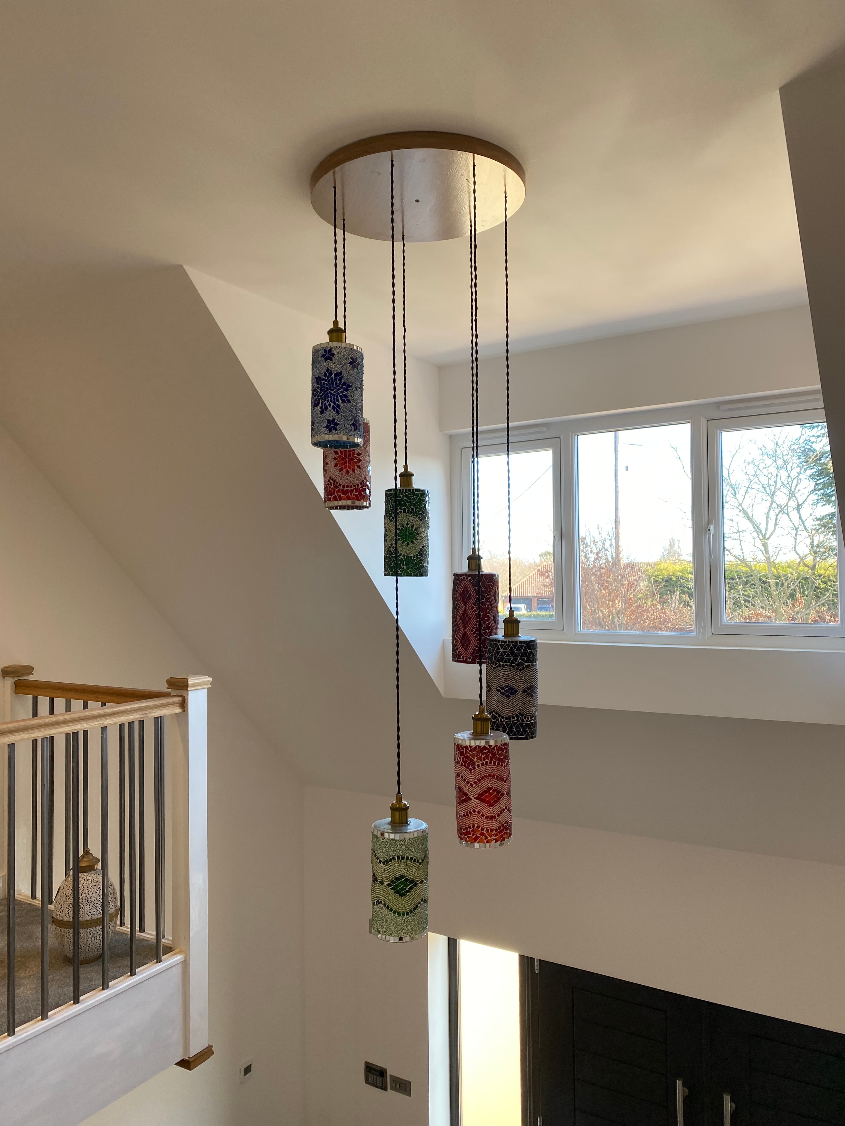 Colourful mosaic pendant lights installed in stairwell void