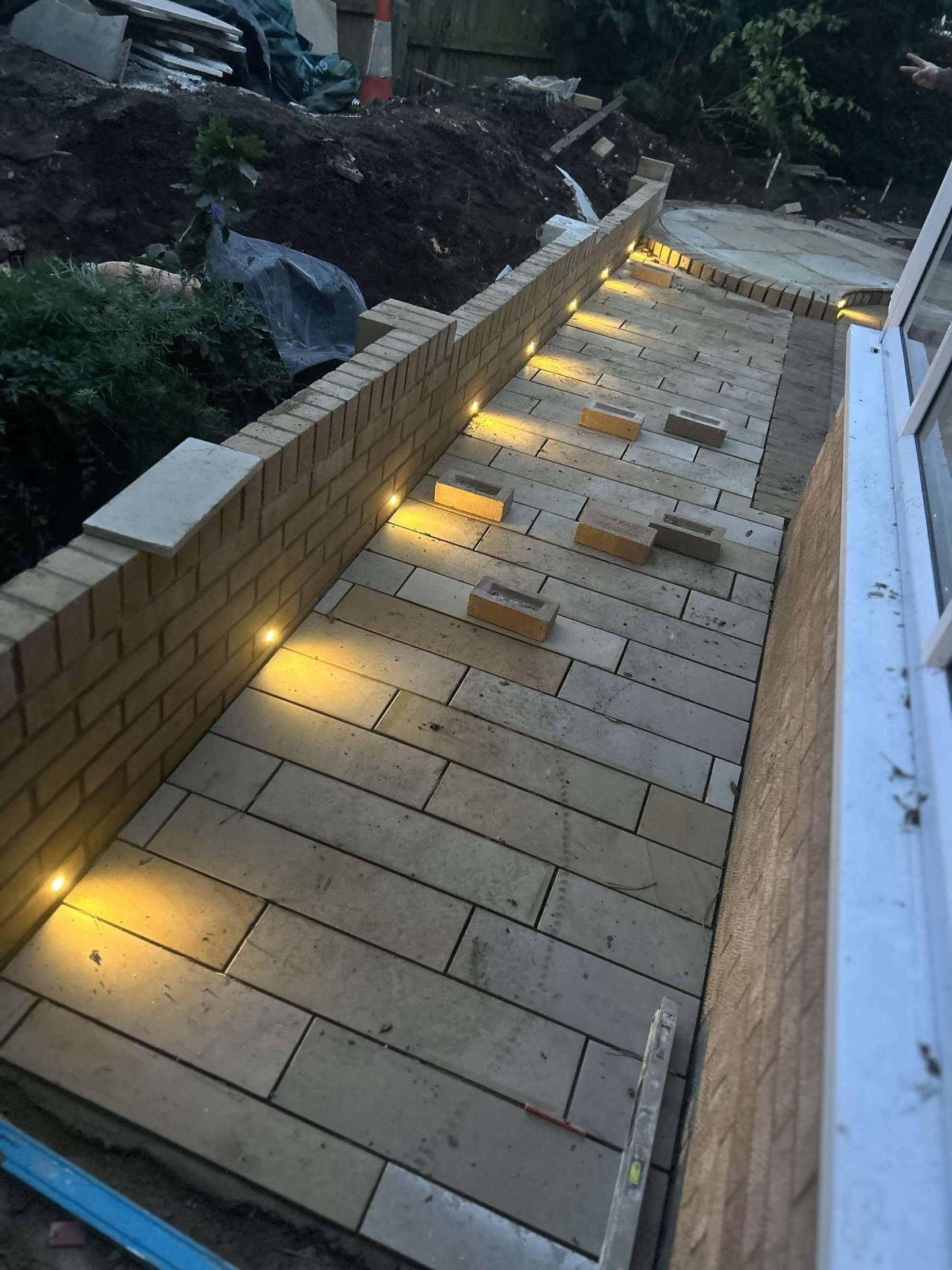 Patio brick wall with recessed lights during installation