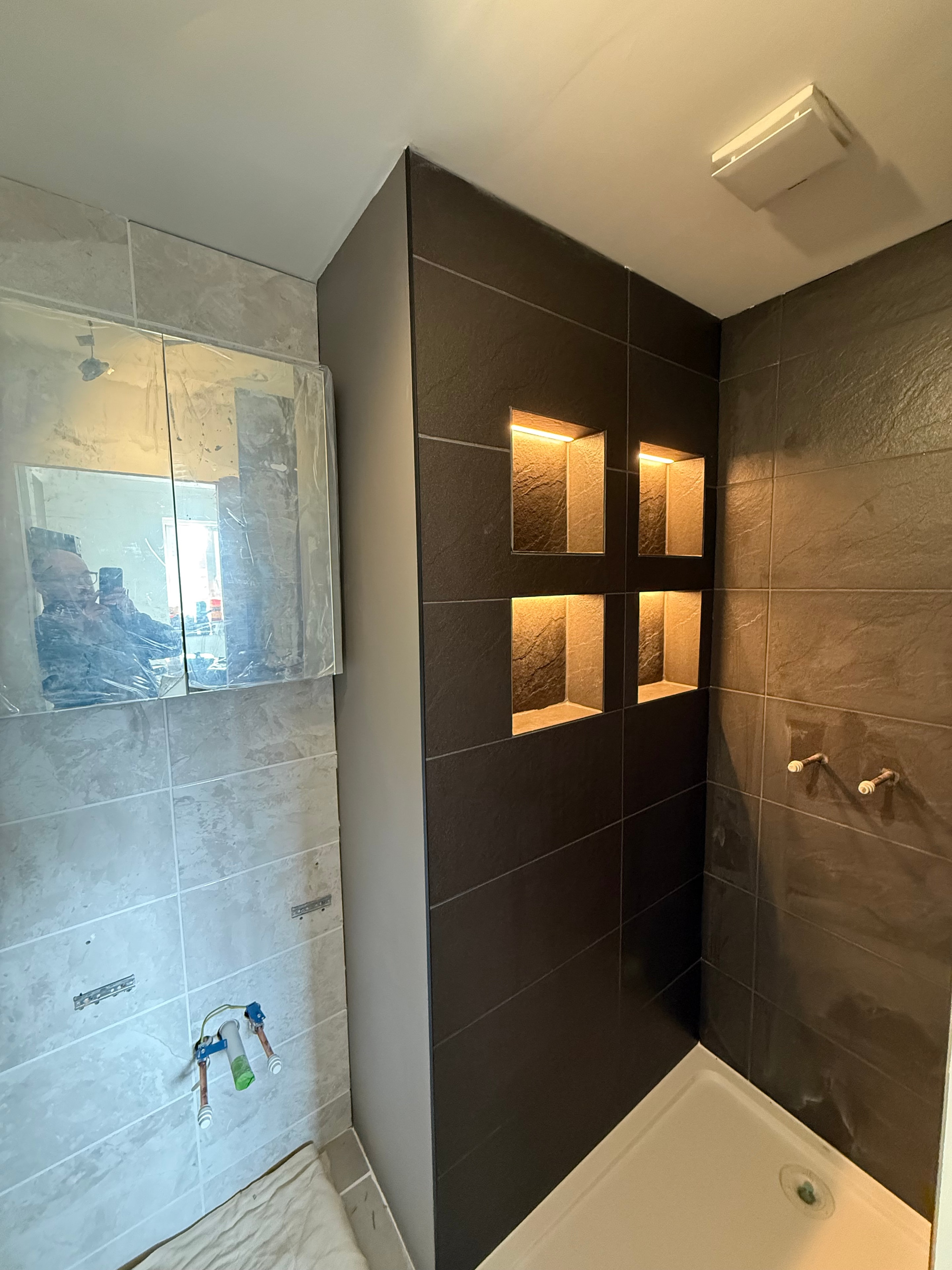 Illuminated tiled bathroom niches wide view